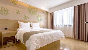 A modern hotel room with a large bed, a bedside table, a wall-mounted light, and a window with curtains. - Greentree Inn Changzhou Zouqu Town Tai fu Times Square Zhenzhong Road Express Hotel (Changzhou)