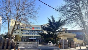 A gated entrance with a building in the background, a clear sky, and trees. - Greentree Inn Qingdao Licang District Shuyuan Road Da Weng Plaza Express Hotel (Qingdao)
