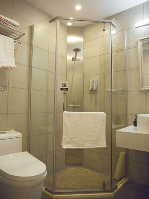 Ein Badezimmer mit Duschkabine, Toilette und Waschbecken.