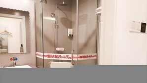 A bathroom with a glass shower enclosure, a sink, and a mirror. - Shell Shanghai Baoshan District Tieli Road Subway Station Tiefeng Road Hotel (Shanghai)