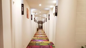 A hallway with a colorful geometric carpet and numbered signs on the walls. - Shell Shanghai Baoshan District Tieli Road Subway Station Tiefeng Road Hotel (Shanghai)