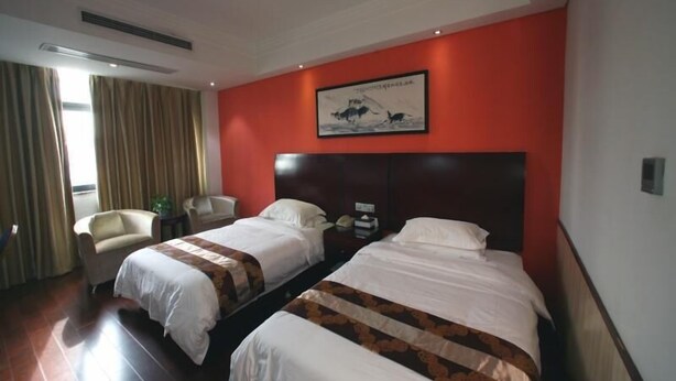 A hotel room with two beds, a large painting on the wall, a chair, and a desk with a lamp. - Shell Shanghai Qingpu District Huaxin Town Xinfu Middle Road Hotel (Shanghai)