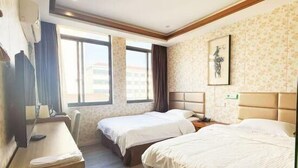 A hotel room with two beds, a desk, a chair, a window, and a wall-mounted artwork. - Shells Shanghai Minhang District Pujiang Town Zhuyuan Road Hotel (Shanghai)