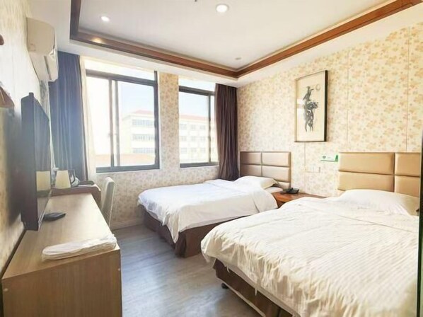 A hotel room with two beds, a desk, a chair, a window, and a wall-mounted artwork. - Shells Shanghai Minhang District Pujiang Town Zhuyuan Road Hotel (Shanghai)