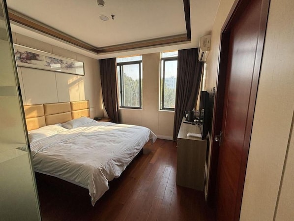 A bedroom with a bed, a desk, and a window. - Shells Shanghai Minhang District Pujiang Town Zhuyuan Road Hotel (Shanghai)