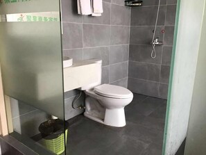 A bathroom with a toilet, a shower, and a trash bin. - Shells Shanghai Minhang District Pujiang Town Zhuyuan Road Hotel (Shanghai)