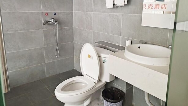 A modern bathroom with a toilet, sink, and shower. - Shells Shanghai Minhang District Pujiang Town Zhuyuan Road Hotel (Shanghai)