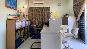 A room with a desk, two chairs, a bookshelf, and a curtain. - OYO 90159 Zahaar Hotel (George Town)