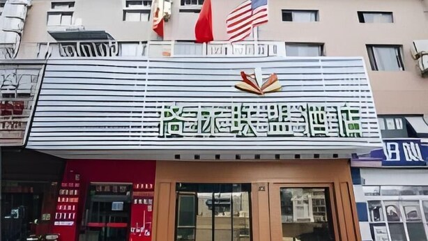 A hotel with a prominent sign featuring Chinese characters and an American flag. - Greentree Alliance Shanghai West Shuichan Road Hotel (Shanghai)