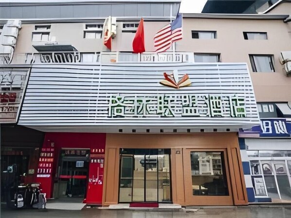 A hotel with a prominent sign featuring Chinese characters and an American flag. - Greentree Alliance Shanghai West Shuichan Road Hotel (Shanghai)