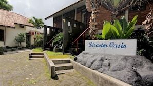 Un edificio con un letrero que dice "Disaster Oasis" y un camino de piedra que conduce a él.