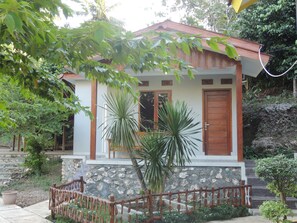 A small house with a stone facade, wooden door, and a small porch with a railing. - Homestay Alam Baru by Zuzu (Wonosari)