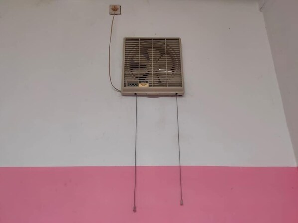 A wall-mounted air conditioner with a control panel and two wires extending from it. - Charisma Residence (Surabaya)