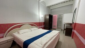 A bedroom with a bed, bedside table, wardrobe, and a shower area. - Charisma Residence (Surabaya)