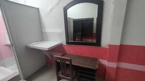 A small, enclosed room with a desk, chair, and a mirror on the wall. - Charisma Residence (Surabaya)