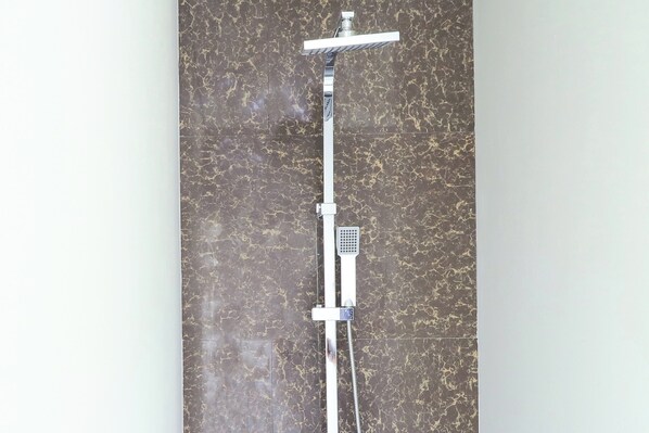 A shower with a control panel and a handheld showerhead mounted on a wall. - Suarsena Villa Ubud (Ubud)