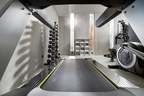 Una palestra moderna con tapis roulant, rastelli per pesi e cyclette.