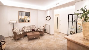 A living room with a sofa set, a coffee table, and a bookshelf. - San Crispino Resort and Spa (Assisi)