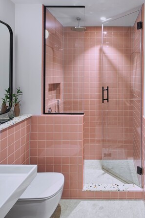 A bathroom with a shower, toilet, and sink.