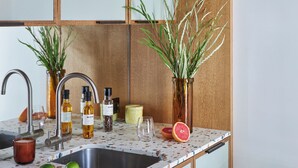 A kitchen with a wooden countertop, a sink, and various kitchen items.