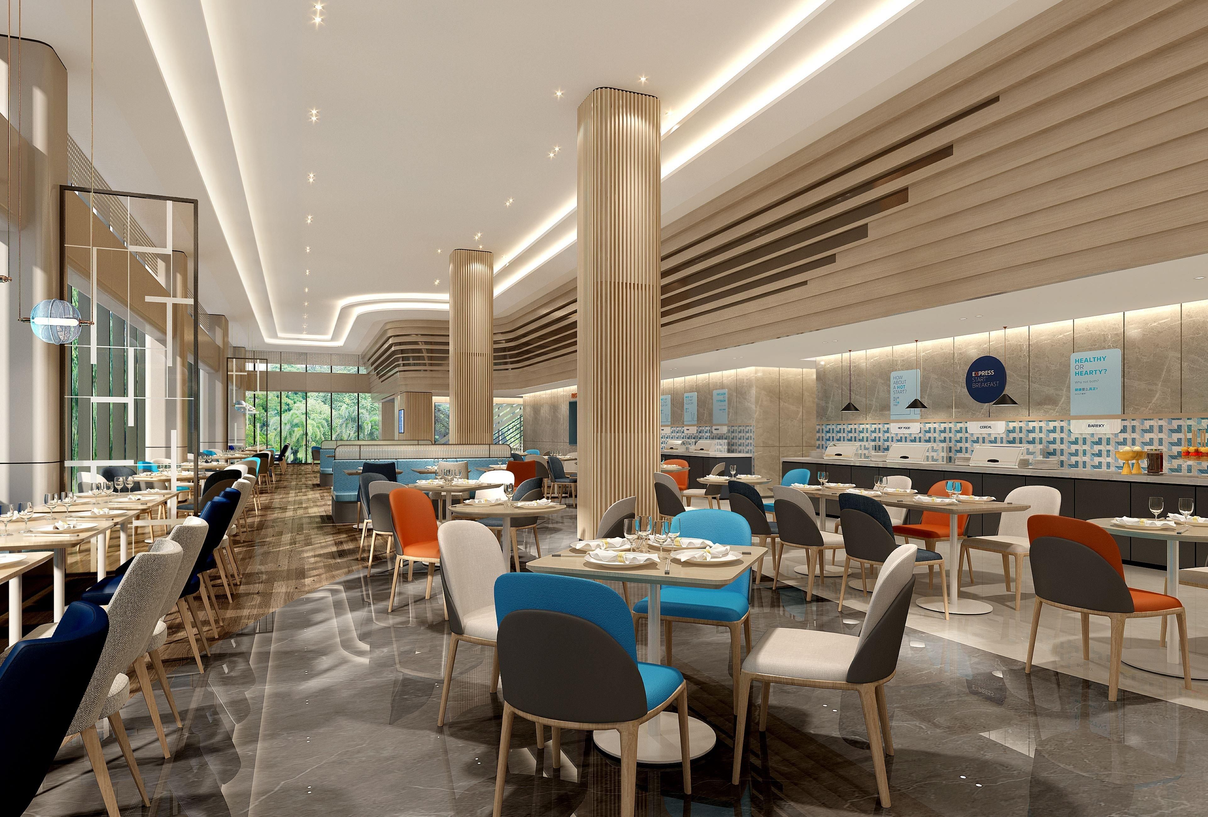 Un restaurante moderno con techos altos, luminarias verticales y diferentes opciones de asientos.