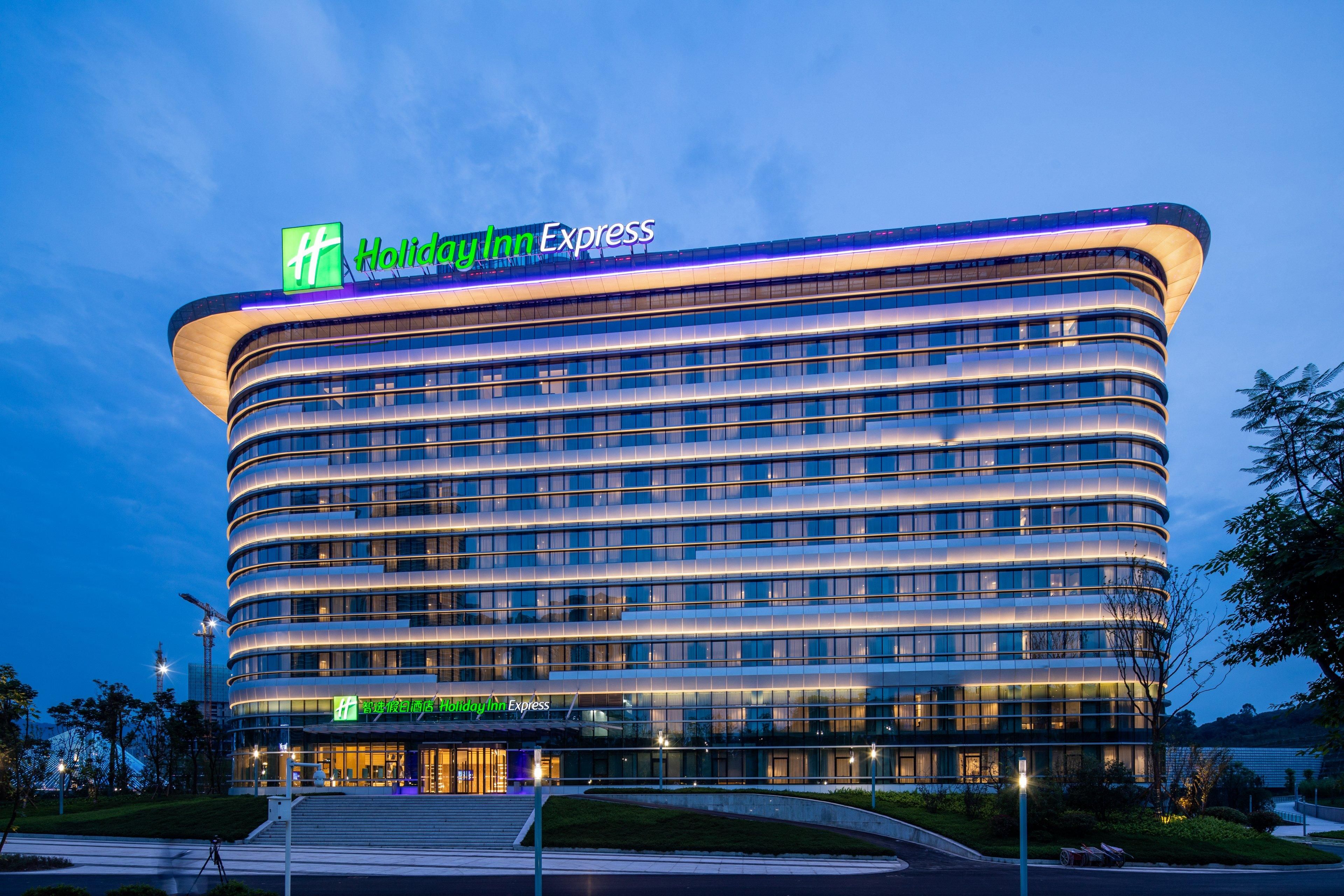 Een modern Holiday Inn Express hotel met een gebogen gevel, meerdere verdiepingen en een opvallende entree.
