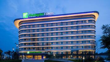 Een modern Holiday Inn Express hotel met een gebogen gevel, meerdere verdiepingen en een opvallende entree.