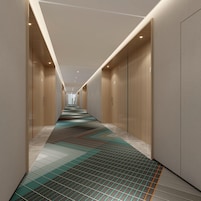 Un pasillo moderno de hotel con suelo estampado, paredes de madera e iluminación empotrada.