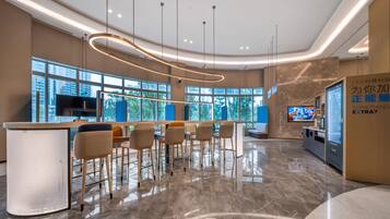 A modern bar area with a marble floor, a central bar counter, and seating.