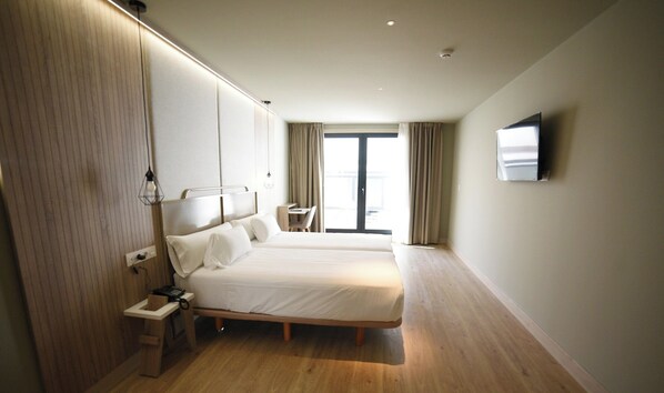 A modern hotel room with a large bed, bedside table, and a TV mounted on the wall. - Imi Hotel & Spa (Ourense)