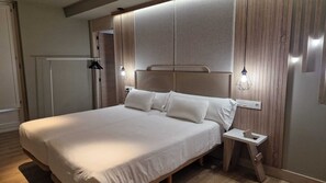 Un dormitorio moderno con una cama grande, paneles de madera en las paredes y dos lámparas de noche.