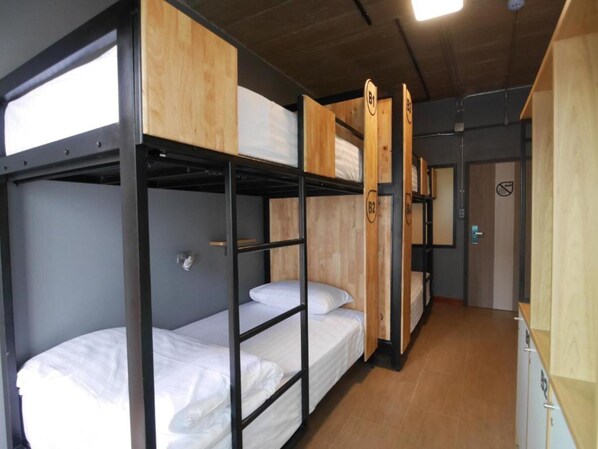 A bunk bed room with wooden headboards and a grey wall. - Ray Hostel (Chiang Mai)