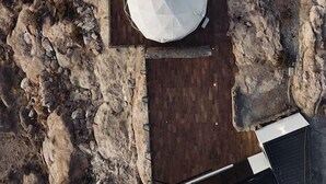 An aerial view of a room with two large, white, dome-shaped structures, possibly tents or canopies, on a wooden platform. - Hotel De Sal Luna Salada (Uyuni)