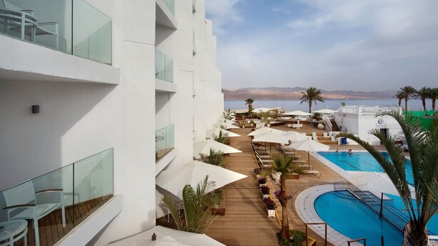 Ein Resort mit Poolbereich, Sitzgelegenheiten im Freien und Meerblick.