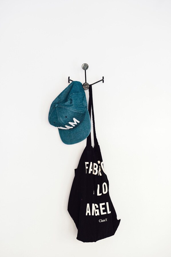 A black bag with white text hanging on a hook. - Veriu Central (Sydney)