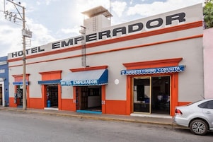 Un edificio con un letrero que dice "HOTEL EMPERADOR" y otro letrero que anuncia "BANQUESES Y COCCINAS CONCHITA".