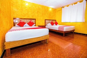 A hotel room with two beds, each with wooden frames and red and white bedding. The walls are yellow, and the floor has a patterned tile design. - OYO Hotel Playa Del Carmen (Playa del Carmen)