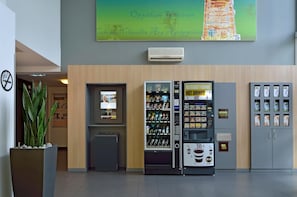 A hotel lobby with a vending machine, a refrigerator, and a coffee machine. - B&B Hotel Köln-frechen (Frechen)