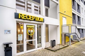 Una recepción de hotel con puerta de vidrio, un letrero que dice 