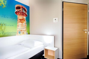 Um banheiro moderno com uma banheira branca, porta de madeira e interruptor de luz na parede.