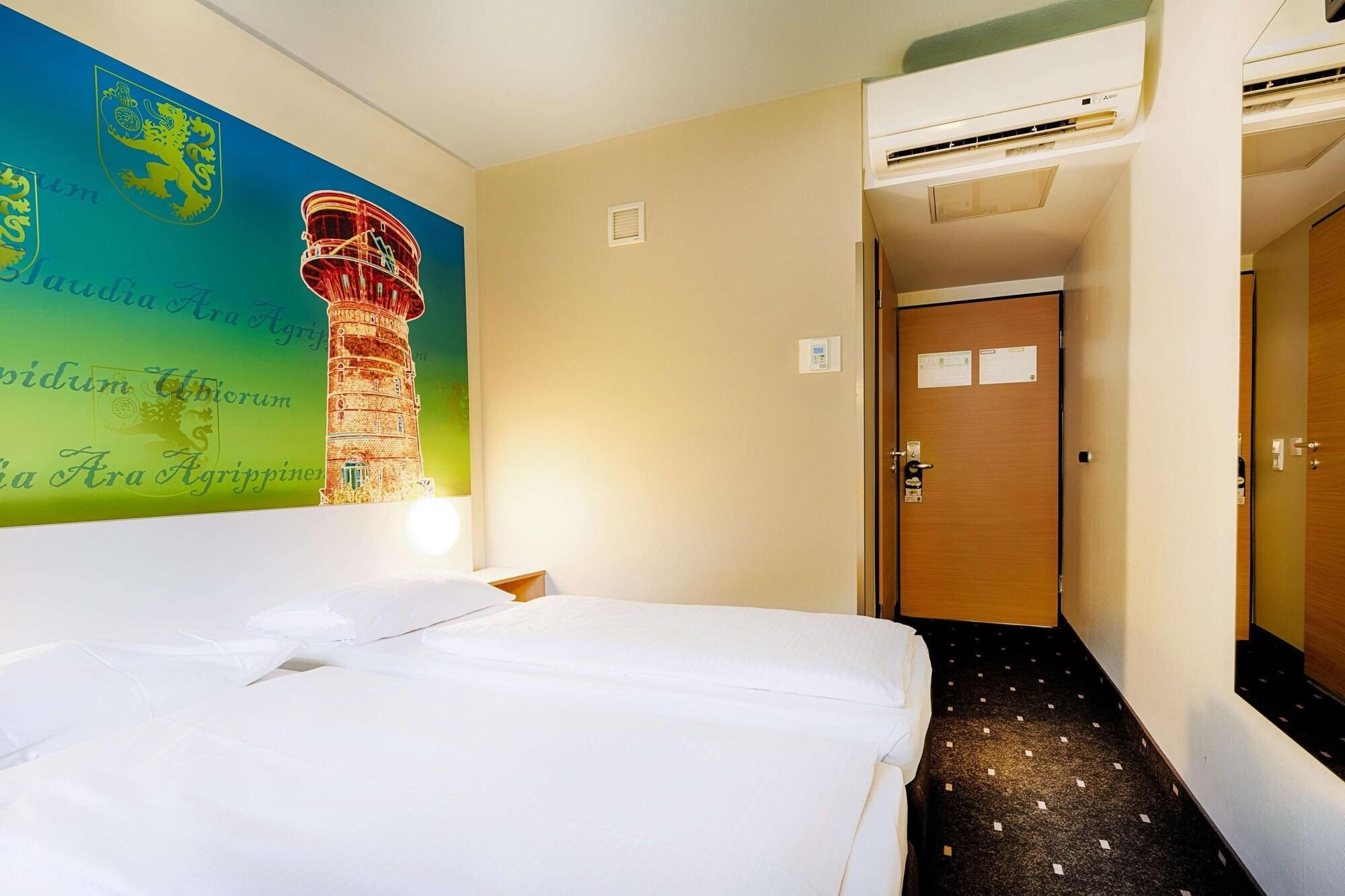 Ein Hotelzimmer mit Bett, Wand mit Wandmalerei, Klimaanlage und Tür.