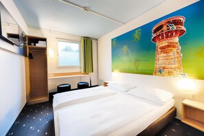 A hotel room with a bed, a window, a wardrobe, and a mural of a tower. - B&B Hotel Köln-frechen (Frechen)