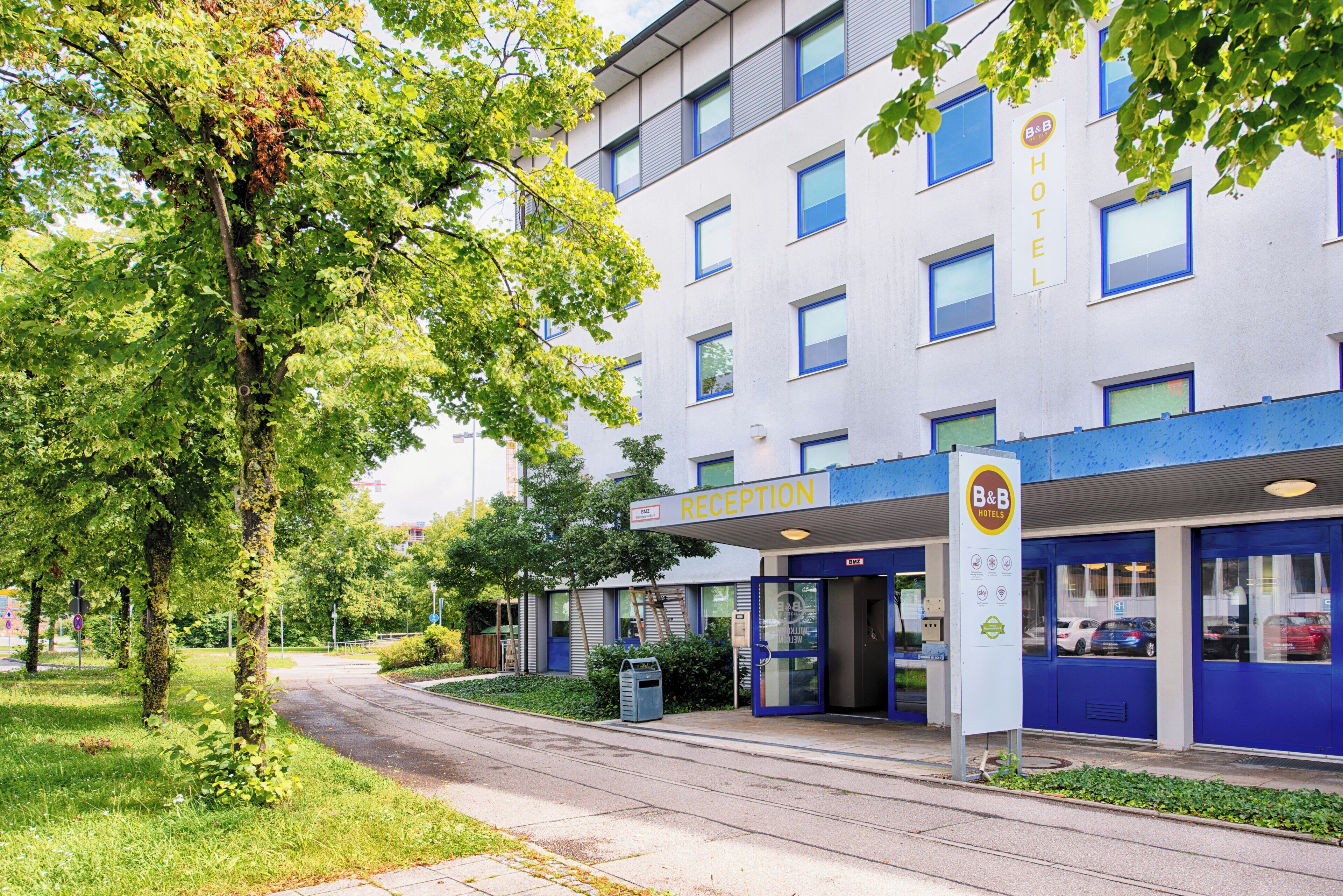 Un hotel moderno con recepción, una entrada azul y un letrero que indica B&B Hotels.