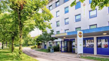 Un hotel moderno con recepción, una entrada azul y un letrero que indica B&B Hotels.