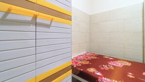 A room with a bed, a wall with horizontal lines, and a tiled wall.