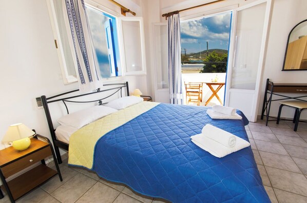 Une chambre à coucher avec un lit, une table de chevet, un bureau et une chaise.