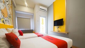 A hotel room with two beds, a TV mounted on the wall, and a window with a view of the outside. - Reddoorz Apartment Near Bundaran Satelit Surabaya (Surabaya)