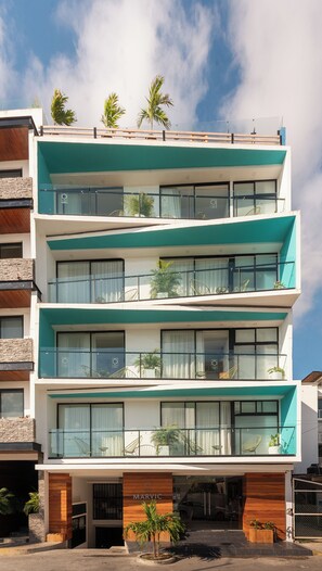 A multi-story building with balconies, large windows, and a sign reading 'MARVIC.' - Marvic Hotel (Playa del Carmen)