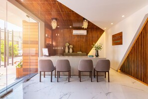 A reception desk with four chairs, a wooden ceiling, a chandelier, and a sign reading 'MARVIC HOTEL BOUTIQUE'. - Marvic Hotel (Playa del Carmen)