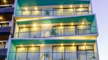 Un hotel de varios pisos con balcones, una zona de recepción y un cartel que dice 'MARVIC'.